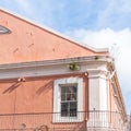 A view up at a peach colored building and blue sky with white clouds