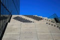 View upstairs on isolated concrete steps with shadows against cloudless deep blue sky with modern house facade Royalty Free Stock Photo