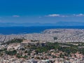 View of the urban texture of Athens with Parthenon ancient temple on Acropolis hill and the Saronic gulf in the background. Royalty Free Stock Photo