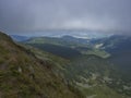 View of valley from grassy hill slopes of hiking trail from Chopok at mountain meadow landscape of ridge Low Tatras Royalty Free Stock Photo