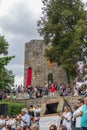 View of various people watching outdoor concert at Vouzela medieval fair, medieval castle as background