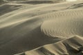 View of a vast expanse of sand dunes with the wind blowing sand across the landscape