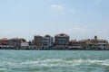 View of the Venice Canal embankment on a warm summer day, with floating boats and old houses