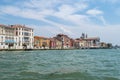 View of the Venice Canal embankment on a warm summer day, with floating boats and old houses