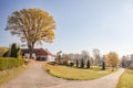 View on very old protected maple tree in autumn colors, old farm and gardens on countryside near South Bohemia in the Czech