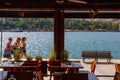 View via cafe windows of three girls walking along the promenade in Chalcis, Greece