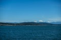 View of a vibrant blue sky above the San Juan Islands and the North Cascades mountain range from the Anacortes Ferry in Washington