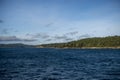 View of a vibrant blue sky above the San Juan Islands and the North Cascades mountain range from the Anacortes Ferry in Washington