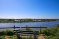 View on viewpoint with empty wooden bench at cycling track with green island in river maas - Between Venlo and Roermond,