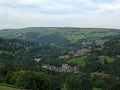 View of the village of cragg vale in the calder valley surrounded by trees and fields