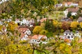 a view of a village from a hill in autumn time with lots of trees and houses in the background Royalty Free Stock Photo