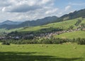 view on village Liptovska Luzna at the foothills of Low Tatras mountains with lush green meadow, forested hills and Royalty Free Stock Photo
