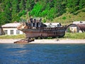 View of the village of Listvyanka from the lake Baikal. an abandoned rusty dilapidated useless ship on the beach