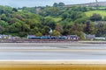 A view from the village of Llansteffan, Wales across the river Towy towards Ferryside with a train approaching the village Royalty Free Stock Photo