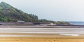 A view from the village of Llansteffan, Wales across the river Towy towards a train on the coastal route