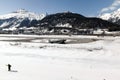 A view of a village in St Moritz, snow covered landscape and mountain, an airplane, a man skiing in the alps switzerland