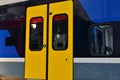 View on wagon of the high speed train with yellow door closed in the rail station.