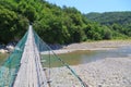 View of walking suspension bridge and mountain river of right