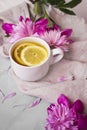View of warm cup of lemon tea with pink flowers Royalty Free Stock Photo