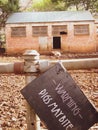 A view of a warning sign at a pig enclose with two pigs in the background Royalty Free Stock Photo