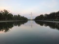 View of the Washington Monument from the Reflecting Pool between trees at sunset in USA Royalty Free Stock Photo