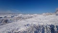 View of waste heaps covered in snow under a blue sky in Donbas, Ukraine