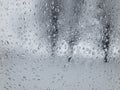 View through water dropson a weeping car window on threes Royalty Free Stock Photo