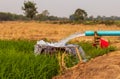 Water flows from pipes into a basin in rice fields near arid soil Royalty Free Stock Photo