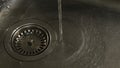 View of the water running from the tap to kitchen sink. Concept. Close-up Royalty Free Stock Photo