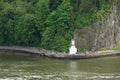 A view from water of Stanley Park Seawall Path with lighthouse, pedestrians and cyclists