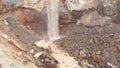 View of waterfall on background of dirty mineral rock. Stock. Dirty waterfall trickle down mineralogical brown rock wall