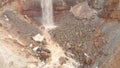 View of waterfall on background of dirty mineral rock. Stock. Dirty waterfall trickle down mineralogical brown rock wall