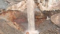 View of waterfall on background of dirty mineral rock. Stock. Dirty waterfall trickle down mineralogical brown rock wall