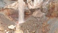 View of waterfall on background of dirty mineral rock. Stock. Dirty waterfall trickle down mineralogical brown rock wall