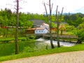 View on waterfall, mill in white building, pedestrian bridge in Park Postojna jama near Postojna Cave Royalty Free Stock Photo