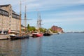 View of waterfront of Copenhagen, old houses with tiled roofs and sailing ship on a sunny summer day. Royalty Free Stock Photo