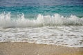 view of a wave near the shore with sand