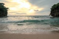 The view of the waves sweeping the white sandy beach at sunset