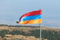 View of waving flag of Armenia with mountain landscape in the background, armenian tricolor flag in summer sunny day