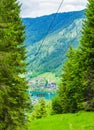 View of Weissensee lake, trees, mountains, cable car and small town below Royalty Free Stock Photo