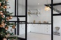 View on a white and black kitchen through the black glass door surrounded by Christmas New year festive decoration Royalty Free Stock Photo