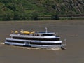 View of white and blue painted excursion passenger ship Vater Rhein with tourists on board enjoying the sunny day on Rhine river.