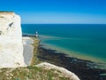View of the white chalk headland cliffs and Beachy Head Lighthouse in the Seven Sisters National park, Eastbourne, England. Royalty Free Stock Photo