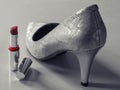 View of white glamour leather high heel shoes and red lipstick women`s accessories chic still life Royalty Free Stock Photo