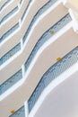 View of a white house facade or a hotel with balcony and blue railing from sloping below