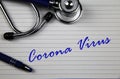 View on white index card with stethoscope and blue ball pen with words corona virus Royalty Free Stock Photo