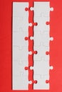 View of white lines of connected jigsaw puzzle pieces on red