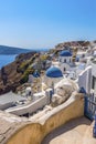 A view of white painted houses, pathways and blue domed churches in the village of Oia, Santorini Royalty Free Stock Photo