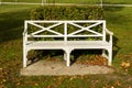 View of white Patio wooden Bench in the green park garden in the fall season