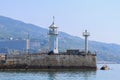 View of the white tower of the old lighthouse in Yalta. In the background of the visitors, the mountains and the sky. Royalty Free Stock Photo